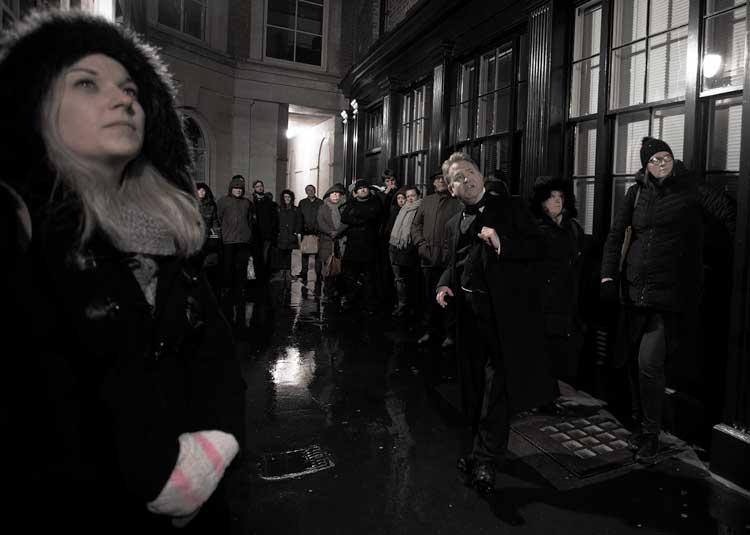 A group on Richard's Ghost Walk looking up at a haunted location.