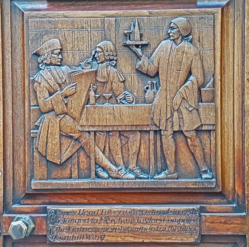 Two men being served wine by a waiter.