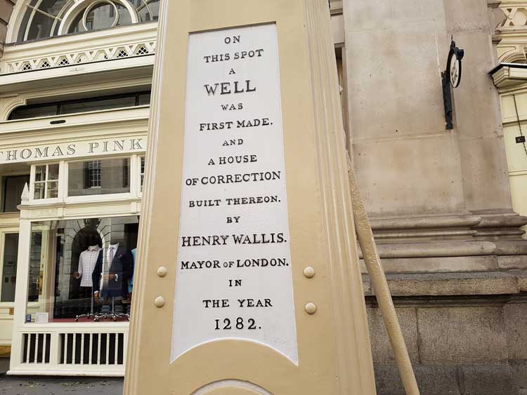 The inscription by the road side giving a history of the well.