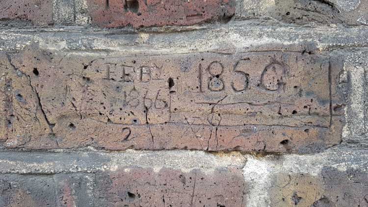 A carving that reads February 1866 followed by the number 185 G.
