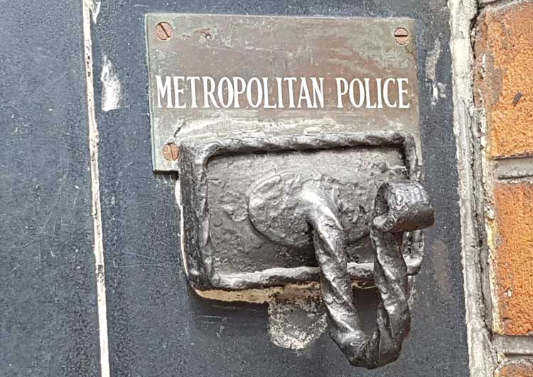 The hook on the wall with the words Metropolitan Police above it.
