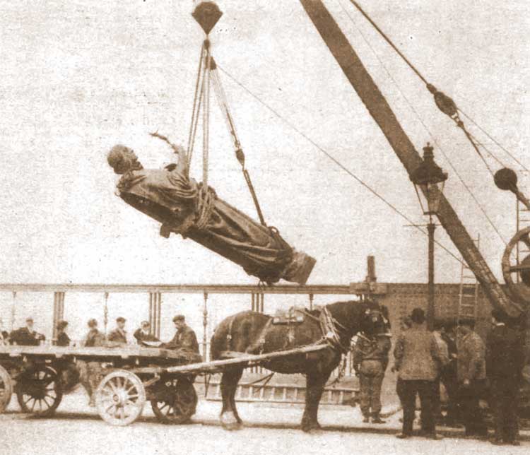 A photograph of one of the statues being lifted into place.