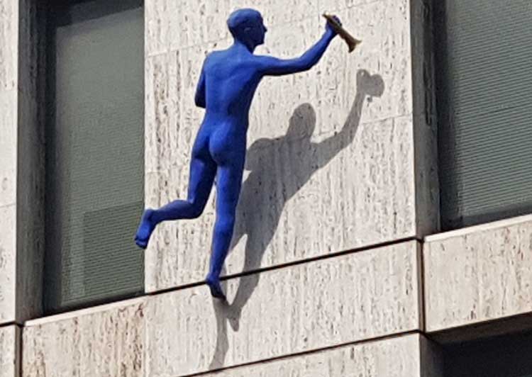 The second blue figure holding a trumpet.