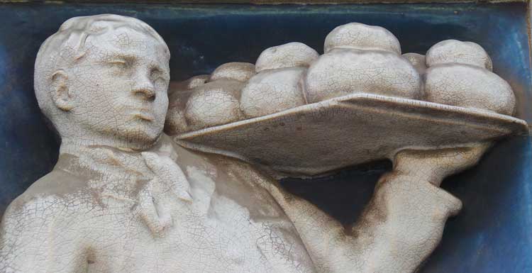 One of the Widegate Street bakers holds a tray of freshly baked loaves.